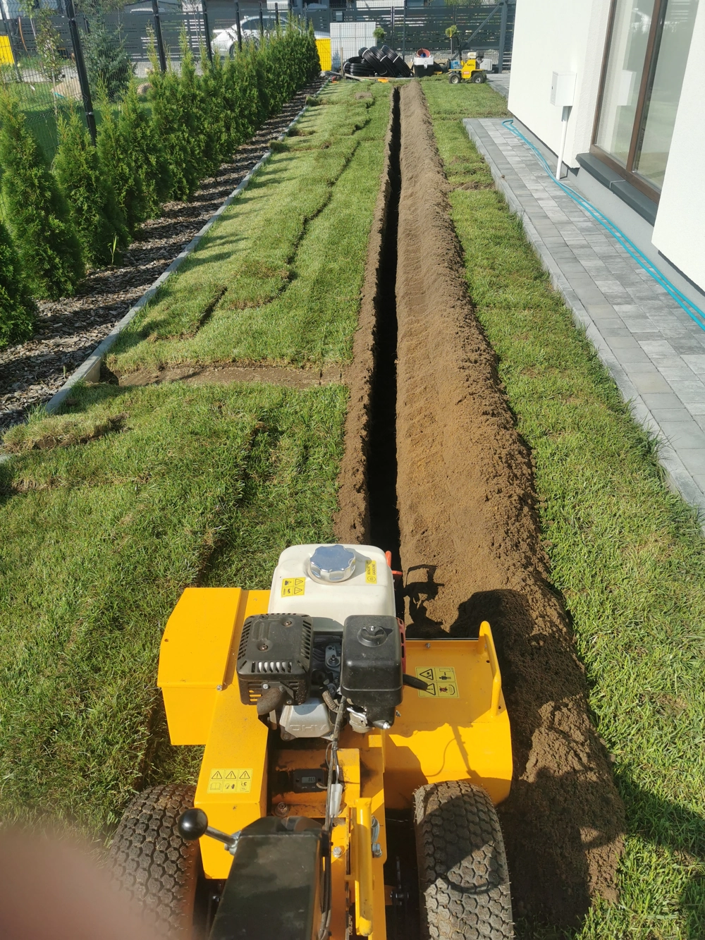 Kopanie rowu pod instalację systemu nawadniania ogrodu maszyną glebogryzarką